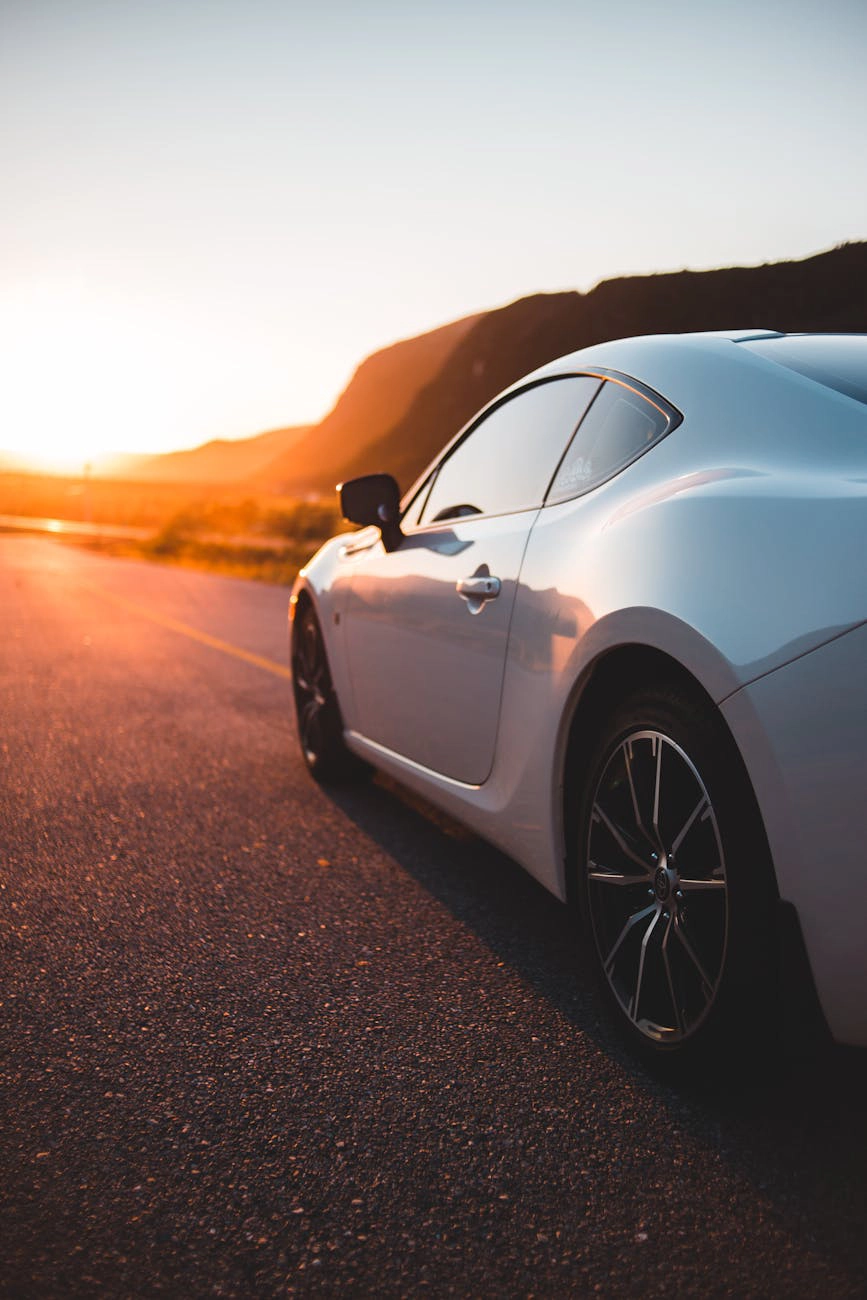 A silver crossover parked at sunset.