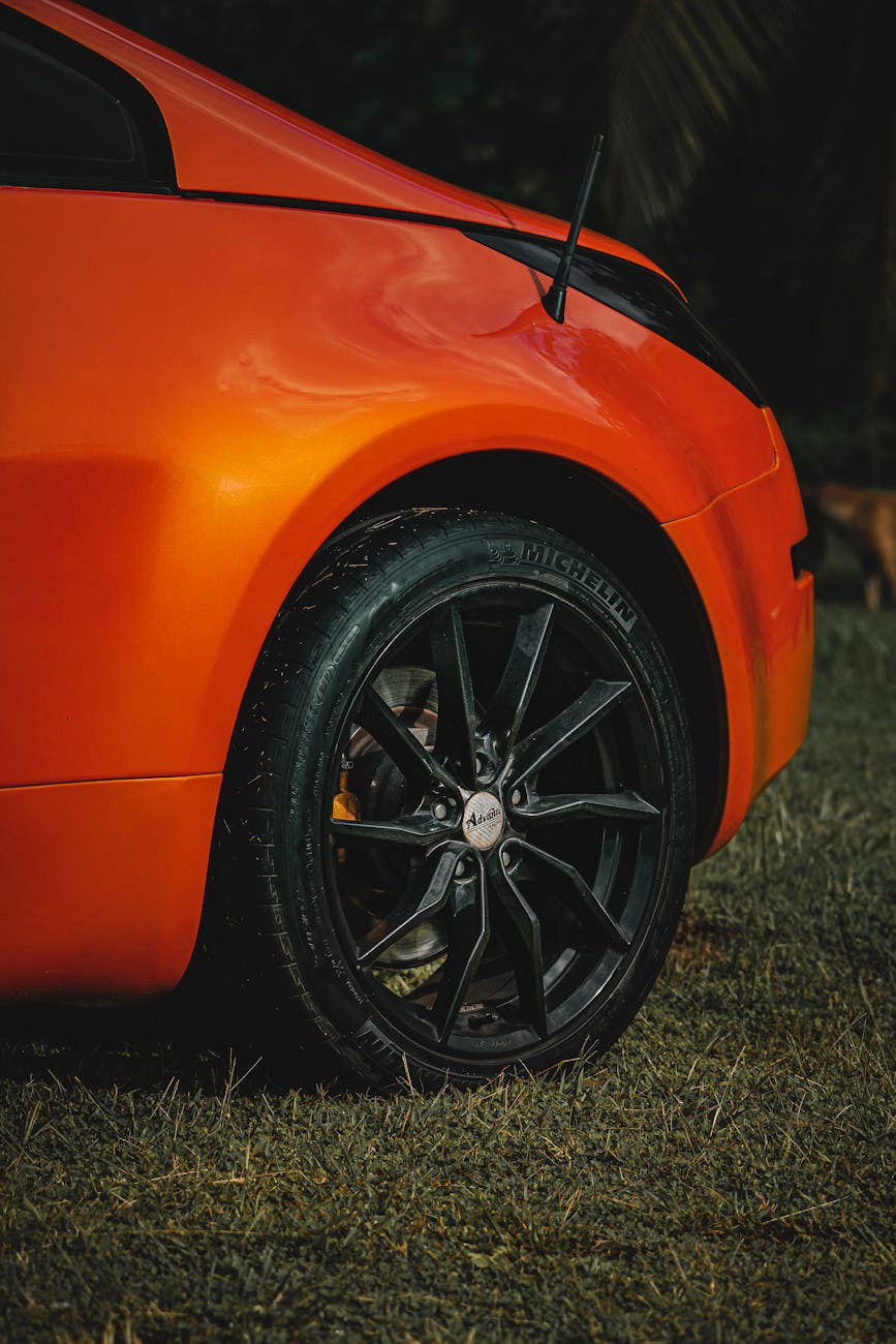 Orange sports car showing a close-up of the wheel and tire.