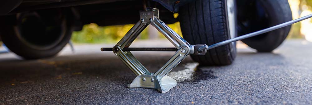 Using a jack stand and a tire jack